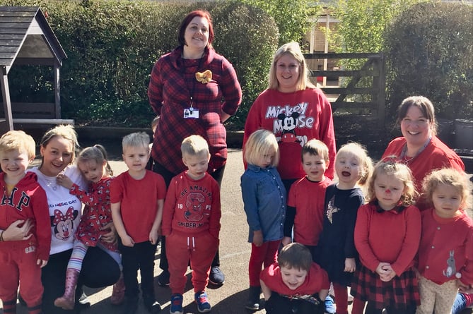 Nursery school and primary school age children dressed in Red alongside their teachers and carers. 