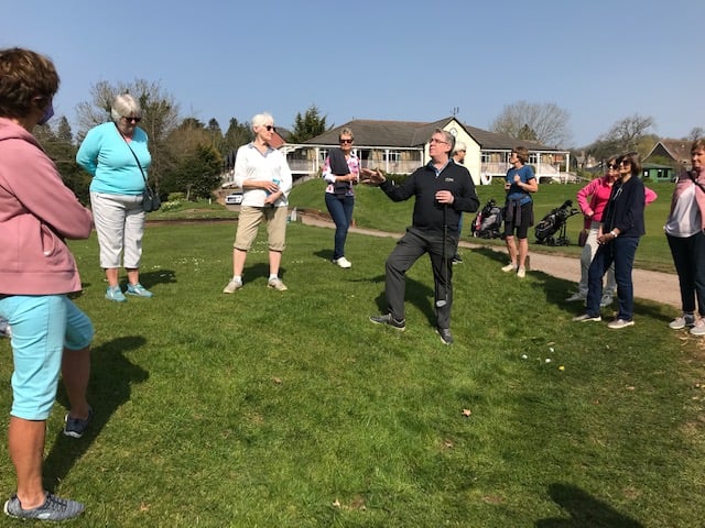 Members of Wells Golf Club gather around on a sunny day. 