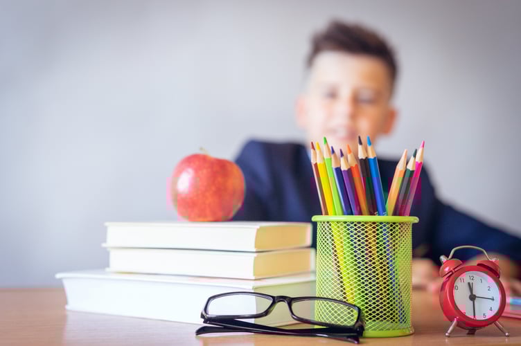 Young boy sat with equipment for school.