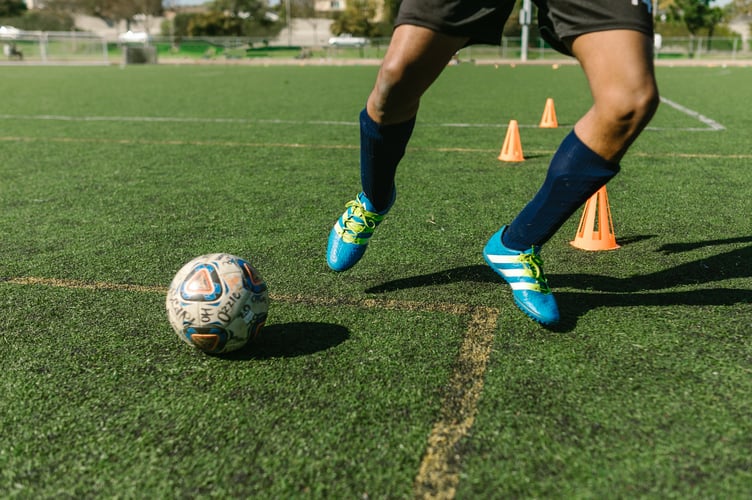 A low shot of someone playing football. 