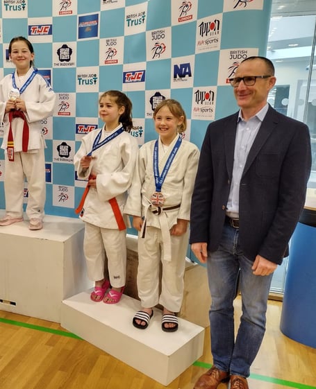 Full Fat Grappling Club stand on the podium to receive their trophies.