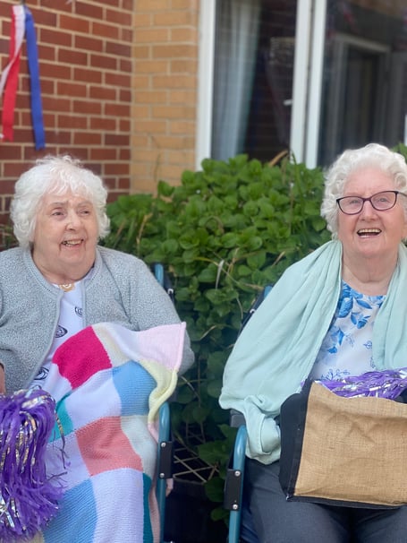 Two ladies sat celebrating at Bloomfield Care Centre.