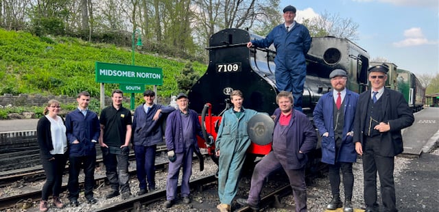 Loco and rolling stock volunteers of all ages gathered for a photo.