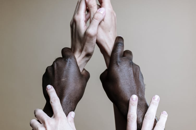 People holding hands and raising each other like a community. 