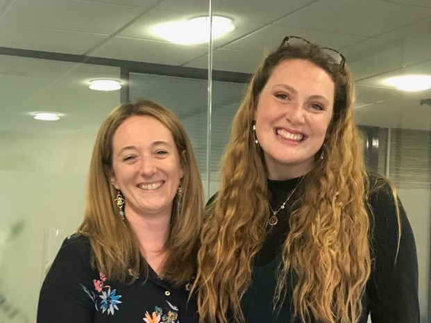 Becky Brooks and Lucy Slade stood handing The Journal over to Lucy. 
