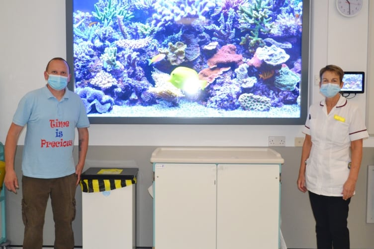 Neil Halford, from Time is Precious, and Di Pressdee, Team Lead Radiographer, standing beside the screen brought in to comfort children during MRI scans.