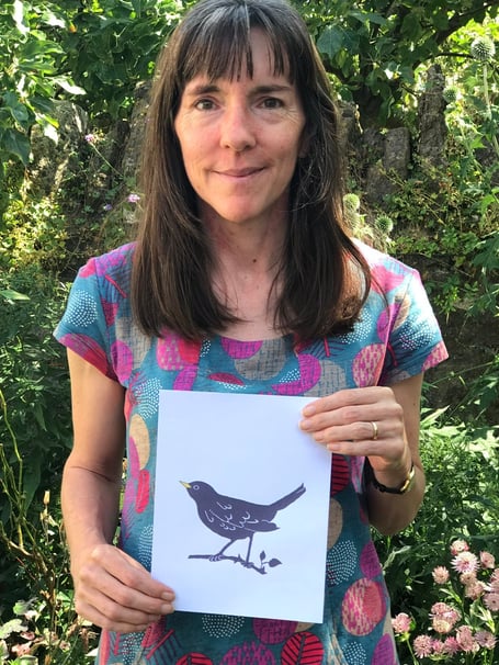 Lucy Empson holding her blackbird design. 