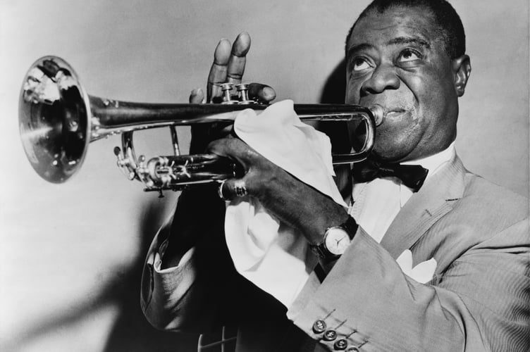 Louis Armstrong playing a musical instrument. 