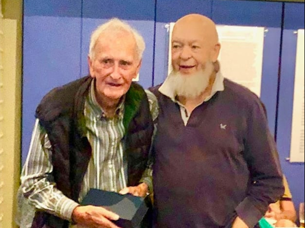 Francis Hillier, Chairman of the Somerset Miners’ Welfare Trust for  25 years receives an engraved glass plaque from former coal miner, Michael Eavis.