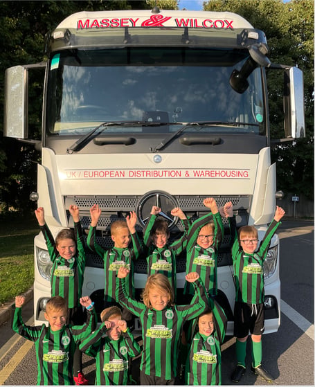 Midsomer Norton Football Club U8s in front of a Massey Wilcox Transport Ltd.