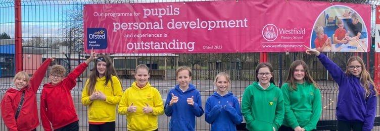 School Values Champions proudly pointing to our banner highlighting our outstanding features - Personal Development.