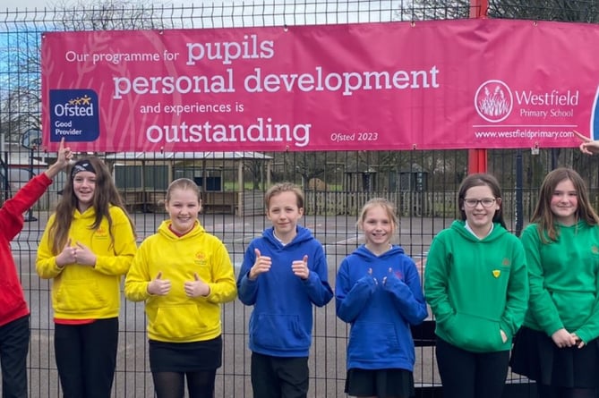 School Values Champions proudly pointing to our banner highlighting our outstanding features - Personal Development.