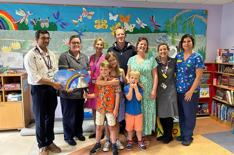  This picture shows George, centre in the orange shirt, in the RUH Children’s Ward to ring the end of treatment bell