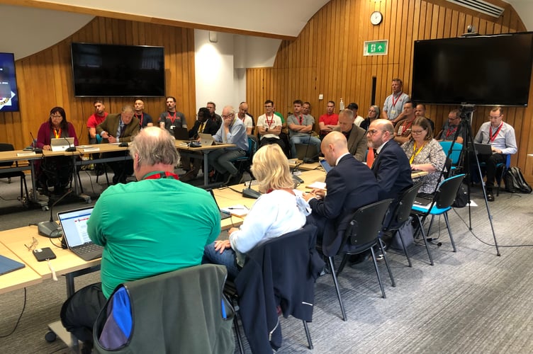 Avon Fire Authority committee with more than a dozen firefighters who attended the meeting in the background on Wednesday, October 4, 2023 