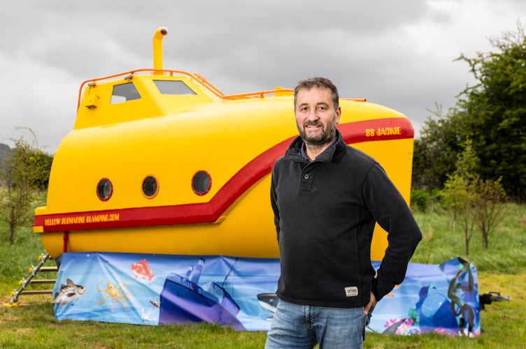 A lifeboat found floating in the sea has been turned into a real-life Yellow Submarine for glamping. Andy Barton, 58, transformed the discarded vessel into a camp-site accommodation. It has a fully-equipped kitchen featuring a fridge, hob, sink, a double-bed, single bunk-bed, a dining area with a sofa and an outdoor BBQ and firepit. Cheddar, Somerset. April 25 2024. Photo released April 26 2024. A lifeboat found floating in the sea has been turned into a real-life Yellow Submarine for glamping.Andy Barton, 58, transformed the discarded vessel into a camp-site accommodation.It has a fully-equipped kitchen featuring a fridge, hob, sink, a double-bed, single bunk-bed, a dining area with a sofa and an outdoor BBQ and firepit.The sub was originally used on a big tanker ship named 'Northsea Pioneer' until it was attacked by Somali Pirates off the East African coast in 2019.