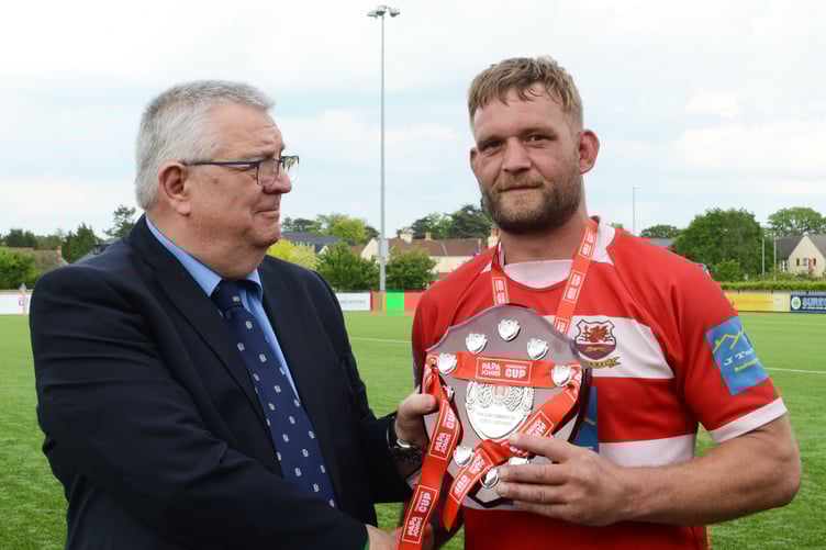 Joey Button is presented with the winning trophy
