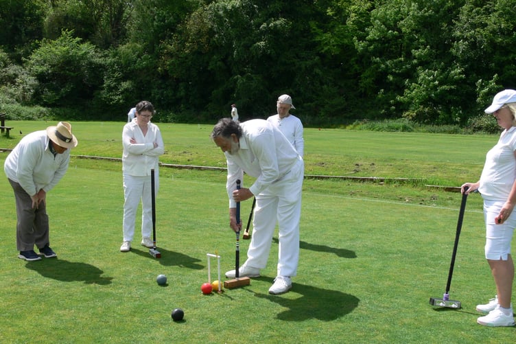 Call the Ref! In the CPCC 'A' versus CPCC 'B' match, referee Brian Wilson watches closely as Phil Hendy attempts to run a hoop while avoiding a crush shot (fault) between the red and yellow balls.