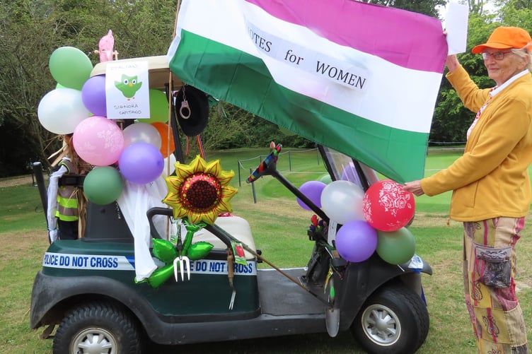 Lady Captain Lin Handley with her buggy festooned with balloons, police light and siren and the Womens' Rights flag.