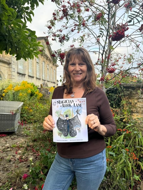 Lydia Hardy holding The Magician of Rook Lane, which aims to inspire young readers while supporting mental health charities.