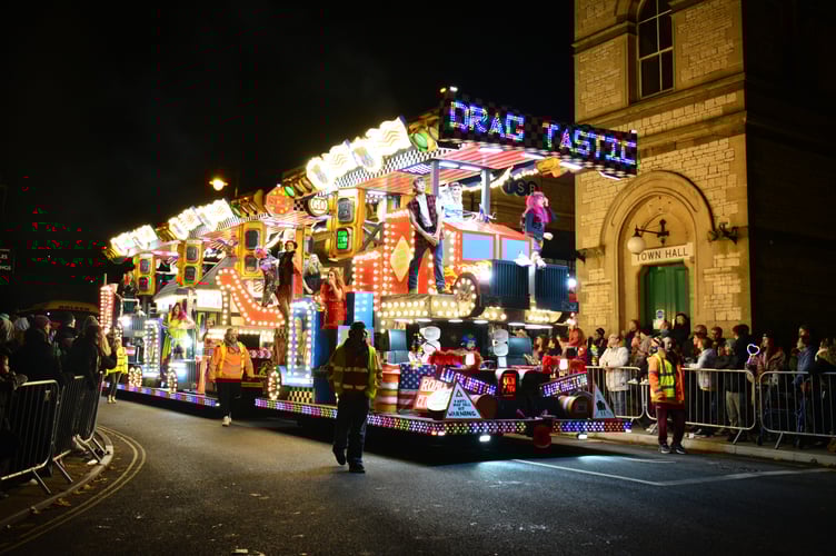 A dazzling illuminated cart makes its way through the streets, lighting up the Midsomer Norton Carnival procession.

