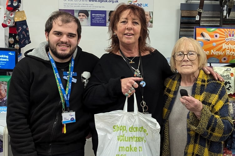Sales Assistant Harry, store manager Julie and volunteer Dawn holding a bag of coal.