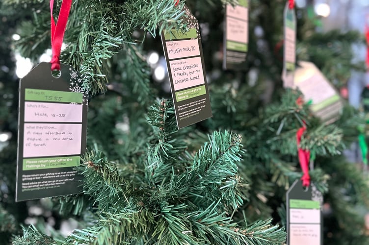 Gift request tags hang on a Christmas tree at Curo's Bath office, where colleagues choose personalised presents for residents in temporary accommodation.