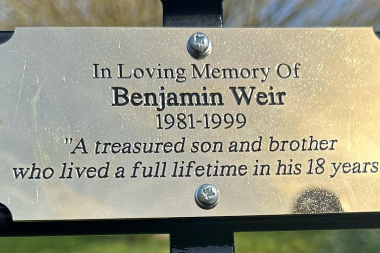The memorial bench plaque for Benjamin Weir at Ninesprings Country Park in Yeovil, Somerset. Photo released April 2 2025. Two brothers surprised their parents with a memorial bench in honor of their late sibling on Mother's day.Jack Weir, 40, and his younger brother George, 38, arranged for the bench to be installed at Ninesprings Country Park in Yeovil, Somerset, in honor of their older brother Benjamin, who passed away in 1999 at the age of 18.Their parents, Robert Weir, 69 and Jane, 68 had tried multiple times over the last two decades to get a bench where Benjamins ashes were buried but were repeatedly turned down by the council.Determined to make it happen, the brothers took matters into their own hands - secretly arranging for the bench to be installed and unveiling it as a surprise on Mothers Day.
