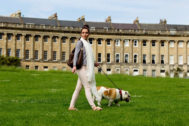 FILE PHOTO - Actress Helen Flanagan walks her dog around the Royal Crescent in Bath in 2014. Photo released April 2025. Residents on one of Britain's most ionic streets say they love living there - but tourists sometimes just 'walk in their homes'. The Royal Crescent is a row of 30 Grade I Listed terrace houses laid out in a sweeping crescent in the city of Bath, Somerset. It was built between 1767 and 1775 and has become one of Britain's most beautiful landmarks appearing in countless period dramas like Bridgerton. The street attracts millions of tourists every year keen to get a photos of its stunning multi-million pound homes.
