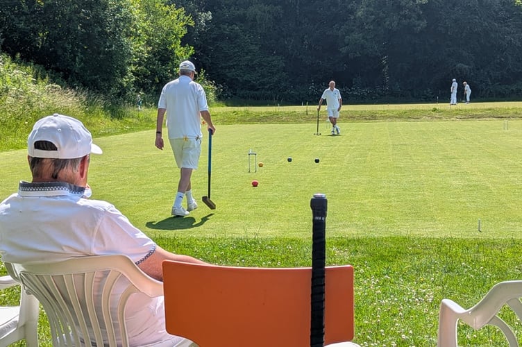 Des Back (CPCC) stalks the red ball as Colin Britt relaxes in the shade. 