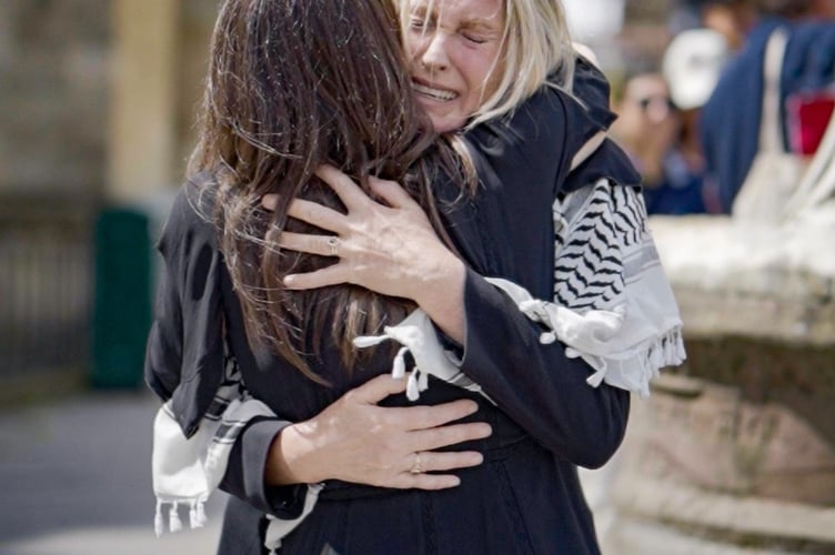 Two people hug at the vigil in Bath on July 3