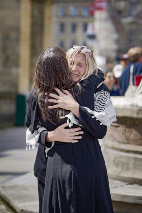 Two people hug at the vigil in Bath on July 3