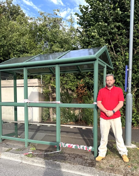 Cllr Gavin Heathcote next to one of the vandalised bus shelters in Orchard Way, Peasedown St John.