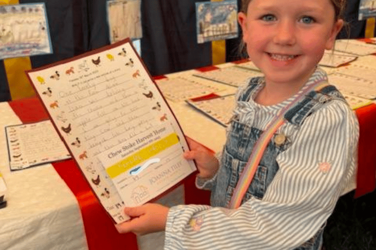 A proud Chew Stoke Church School pupil shows off her work, which formed part of this year's 'Harvest Home'