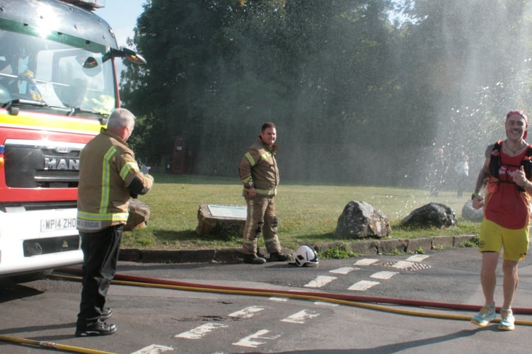 Scott Butler enjoying the water hoses on the village green at Hinton Blewett