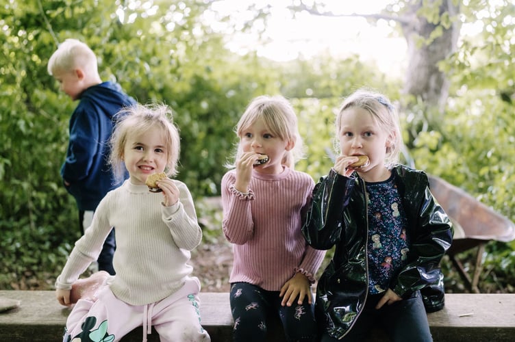 Three youngsters enjoying s'mores during a special forest school event held at St Benedict's for nursery children