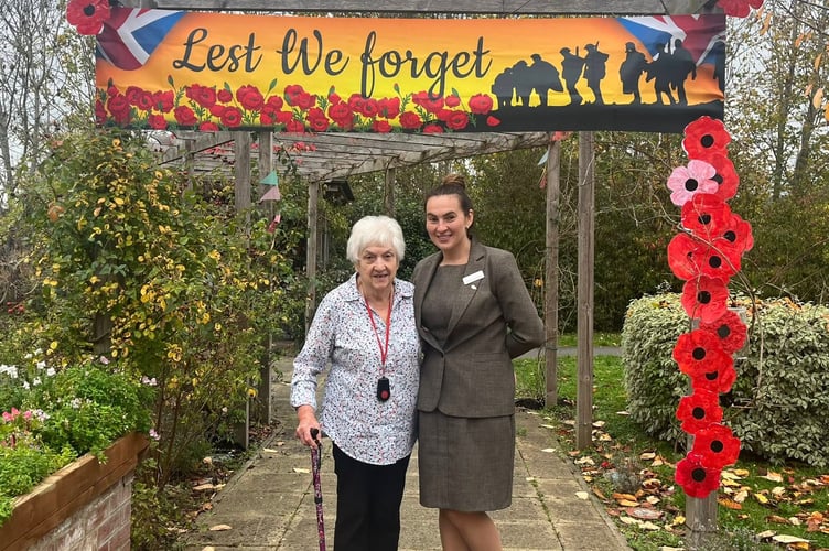Resident diane and manager Claudia Costinean with the 'Lest We Forget' display created at the Kingfisher Lodge Care centre in Saltford for Remebrance