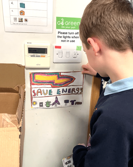 A member of the school’s eco-team with one of their new ‘Save Energy’ posters.