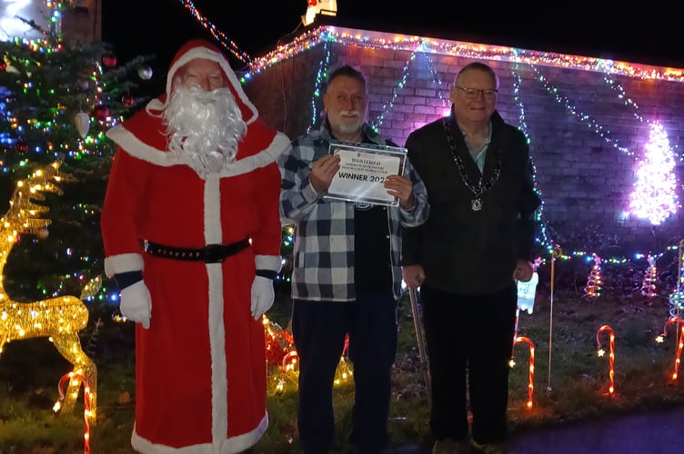 Presenting Mr Jeremy Hault with his winning certificate are chairman of Westfield Parish Council Cllr Philip Wilkinson (right) and Father Christmas