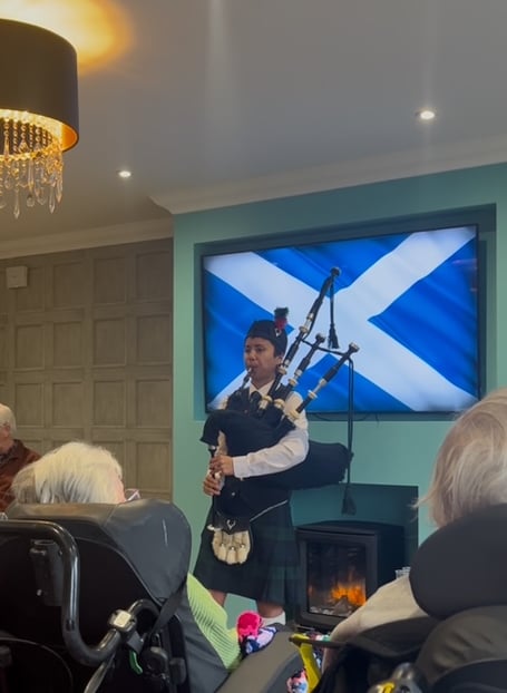 Ruby playing the bagpipes in lounge for residents and visitors of Kingfisher Lodge in Saltford
