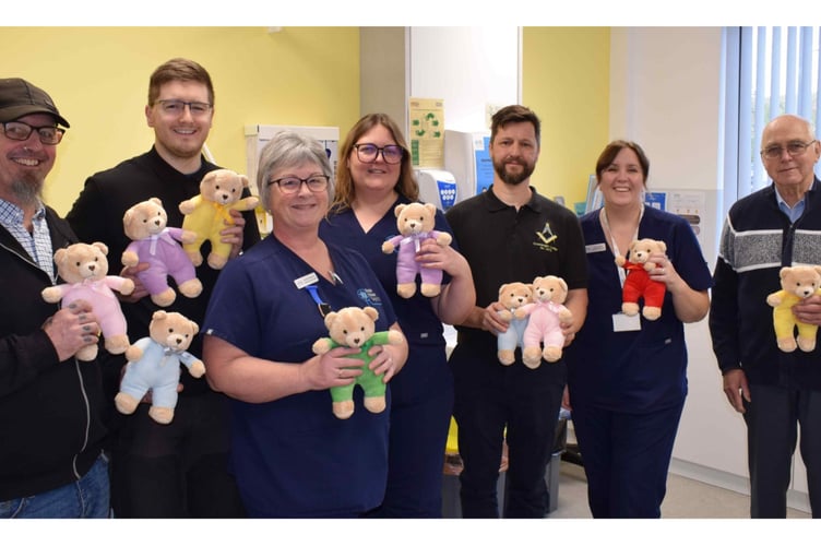 Staff in Hope House Surgery, Radstock, take delivery of a teddy donation from Midsomer Norton Freemasons.