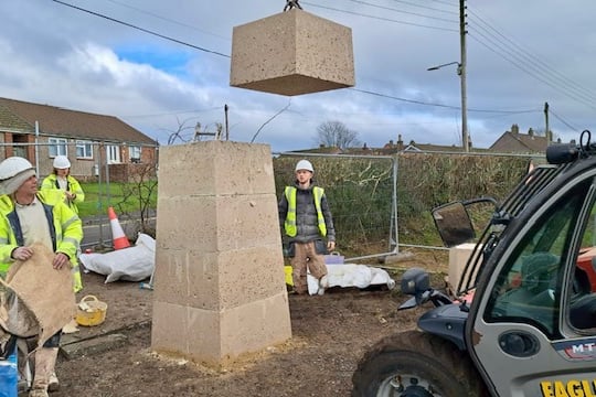 The new war memorial at Peasedown St John being hoisted into place by local contractors.