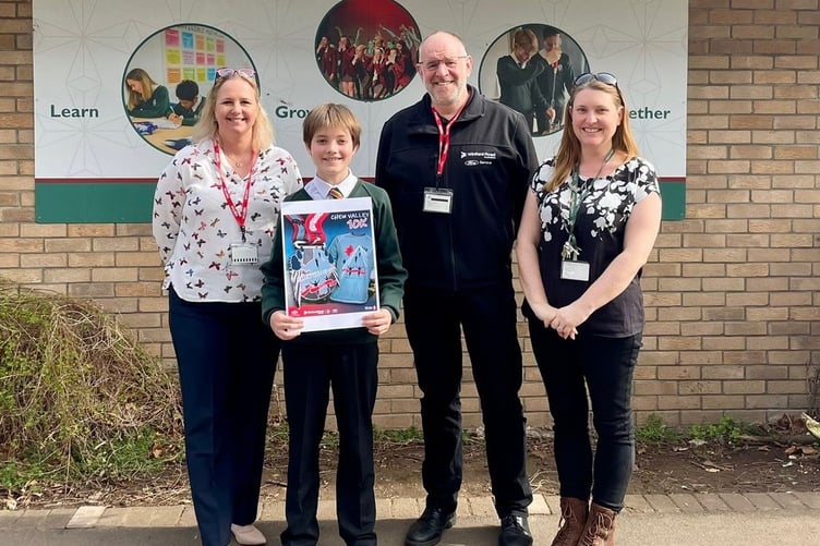 Chew Valley School pupil Rufus Keeton holding up his winning 10K shirt and medal design.