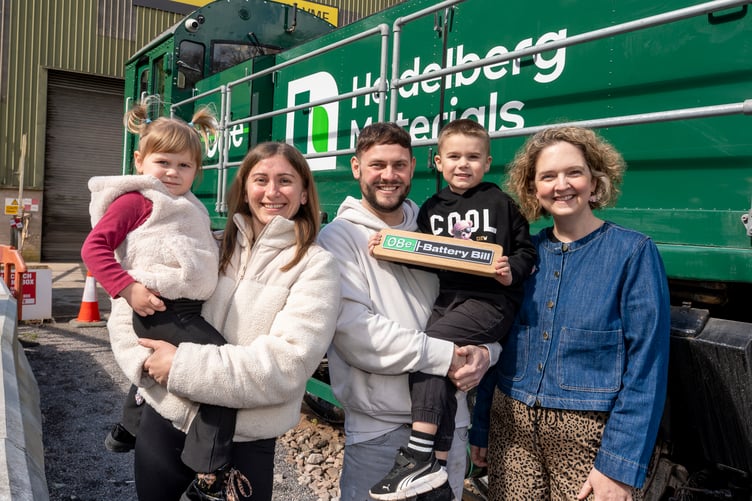 Winner Cillian Gallagher holding the name he chose for the new electric loco with his family and MP Anna Sabine.
