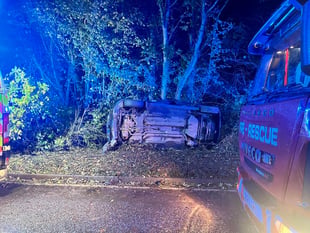 Driver trapped as car crashes and overturns