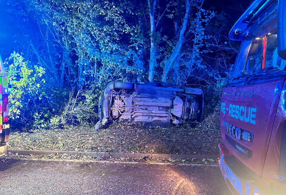 Driver trapped as car crashes and overturns
