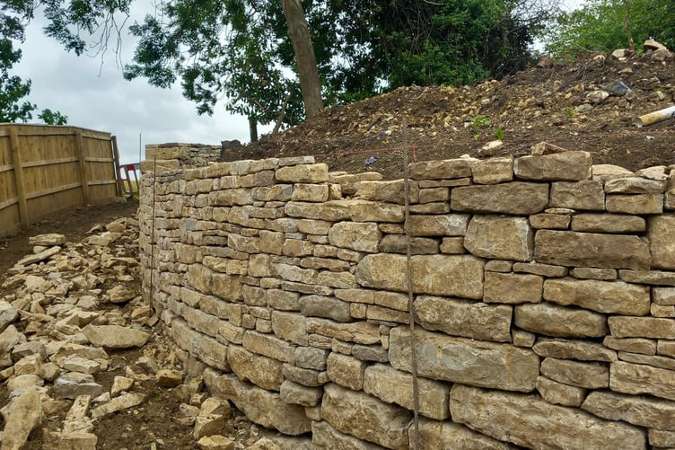 Work on the wall at Holy Trinity is being undertaken by local stone-mason Colin Clutterbuck.