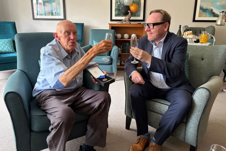 Vice-chancellor of the University of Bath presenting resident Richard with a medal in recognition of his long service.