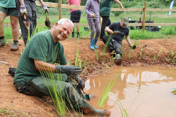 Volunteers with Friends of Somer Valley getting stuck in to planting at the Wellow Brook's new pond.