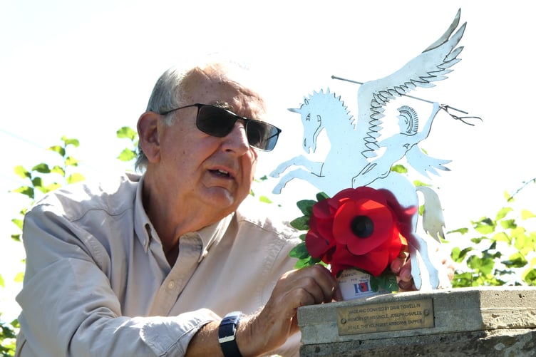 RBL member Will Nicol places a poppy posy tribute to Sapper Joseph Beale on behalf of his late nephew.