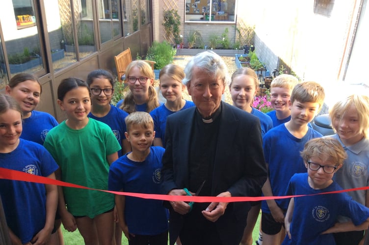 Father Martin officially opens the new sensory garden with pupils at St Benedict's Catholic Primary School.